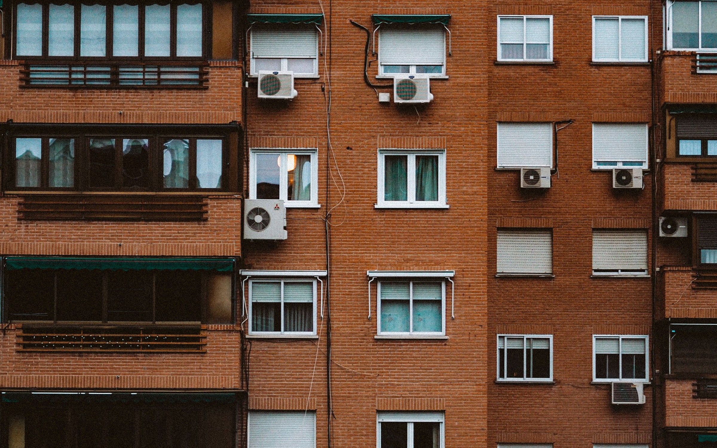 Fachada de ladrillo de un bloque de viviendas con ventanas renovadas